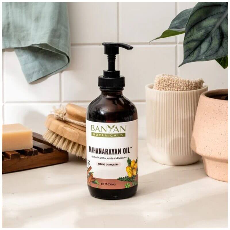 Bottle of Banyan Botanicals Mahanarayan Oil on bathroom sink