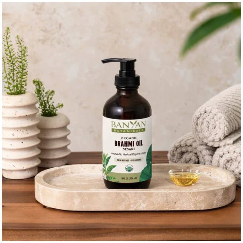 Banyan Botanicals Organic Brahmi Oil on table with towels and plants